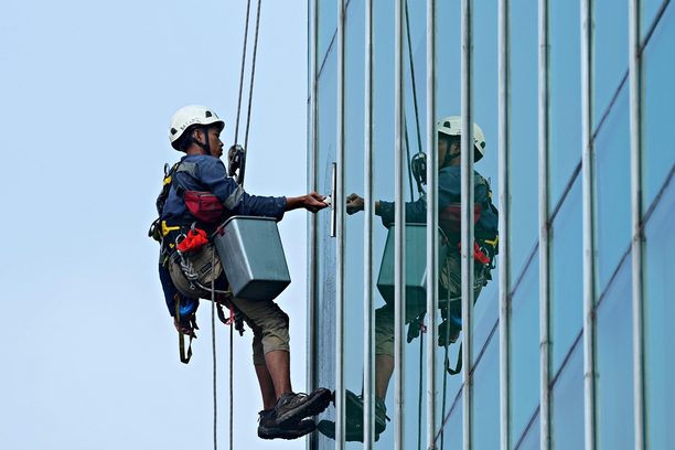 Window cleaners working on a glass building facade